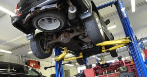 An SUV on a lift, having its wheel alignment assessed in Wichita, KS
