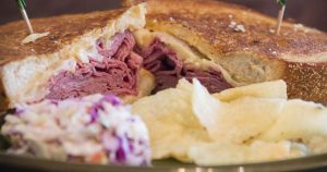 A Reuben sandwich with potato chips and coleslaw served at a local deli in Wichita, KS